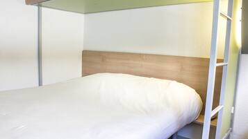 A bunk bed with a wooden headboard and a white mattress.