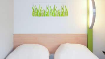 Una habitación de hotel con una cama, una lámpara de pared y un adhesivo mural con diseño de hierba.