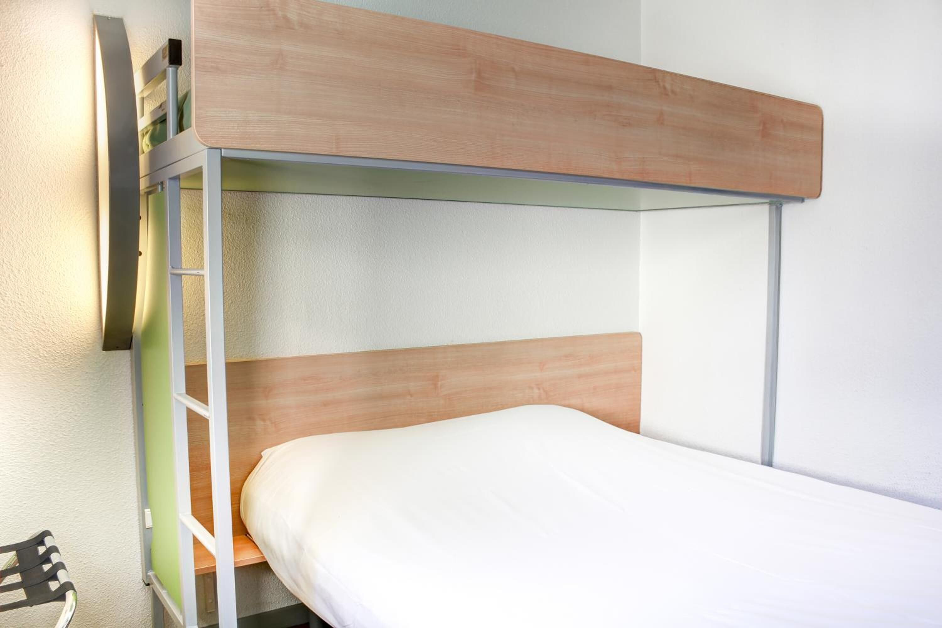 A bunk bed with a wooden headboard and a ladder.