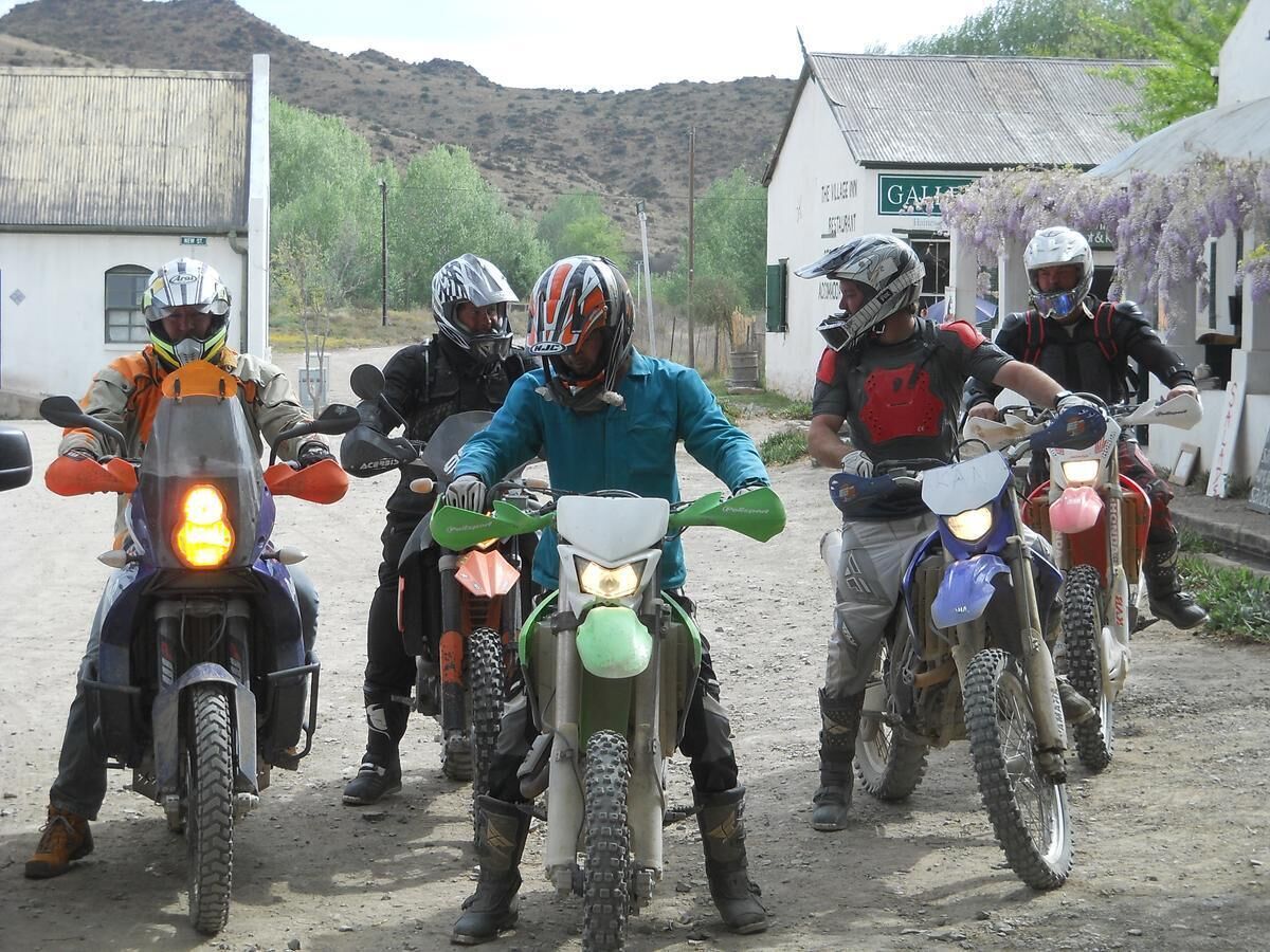 Un grupo de motociclistas en un camino de tierra.