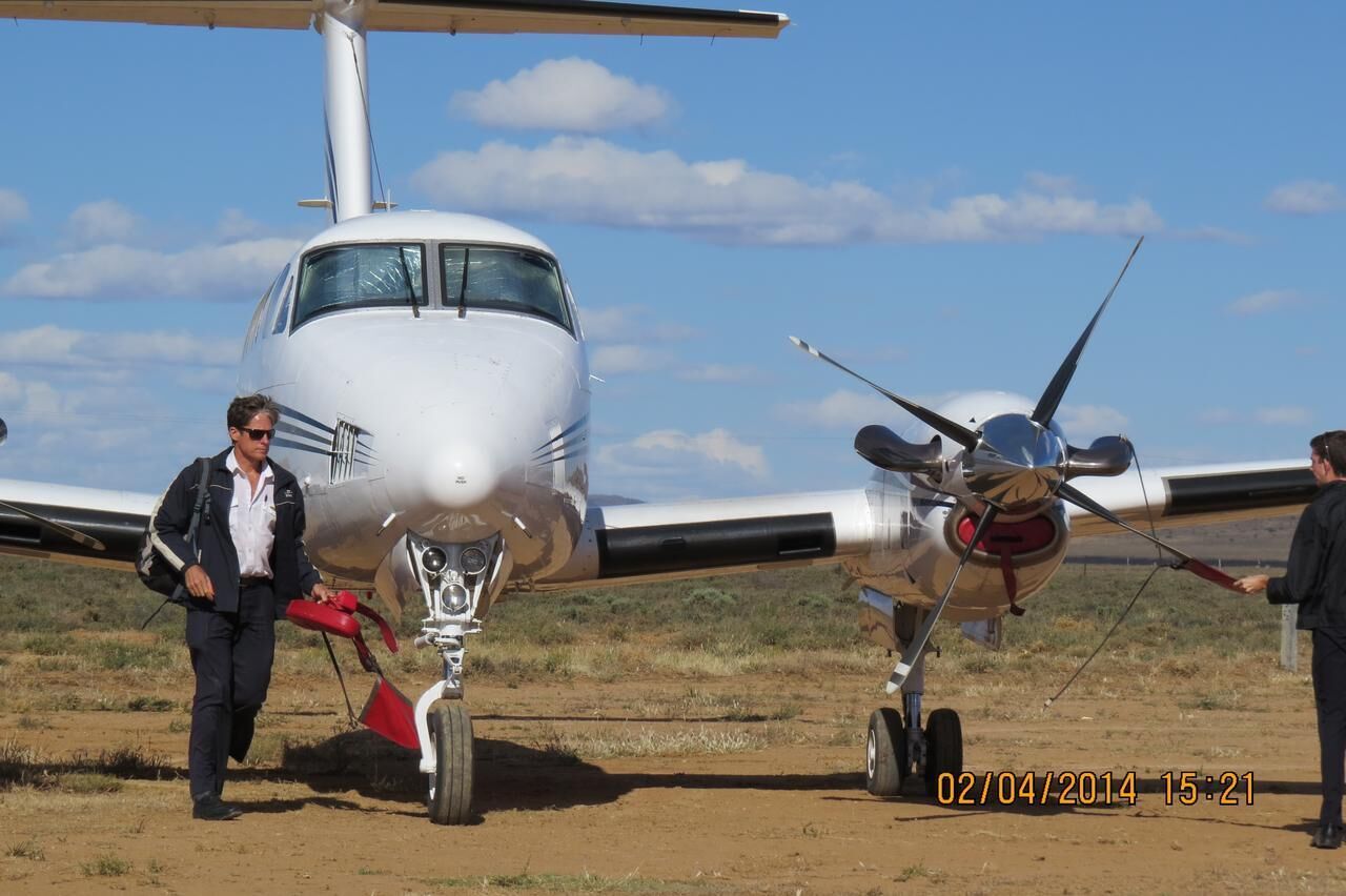 A small aircraft with two people standing beside it.