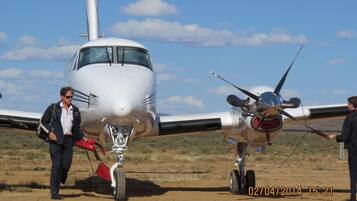 A small aircraft with two people standing beside it.