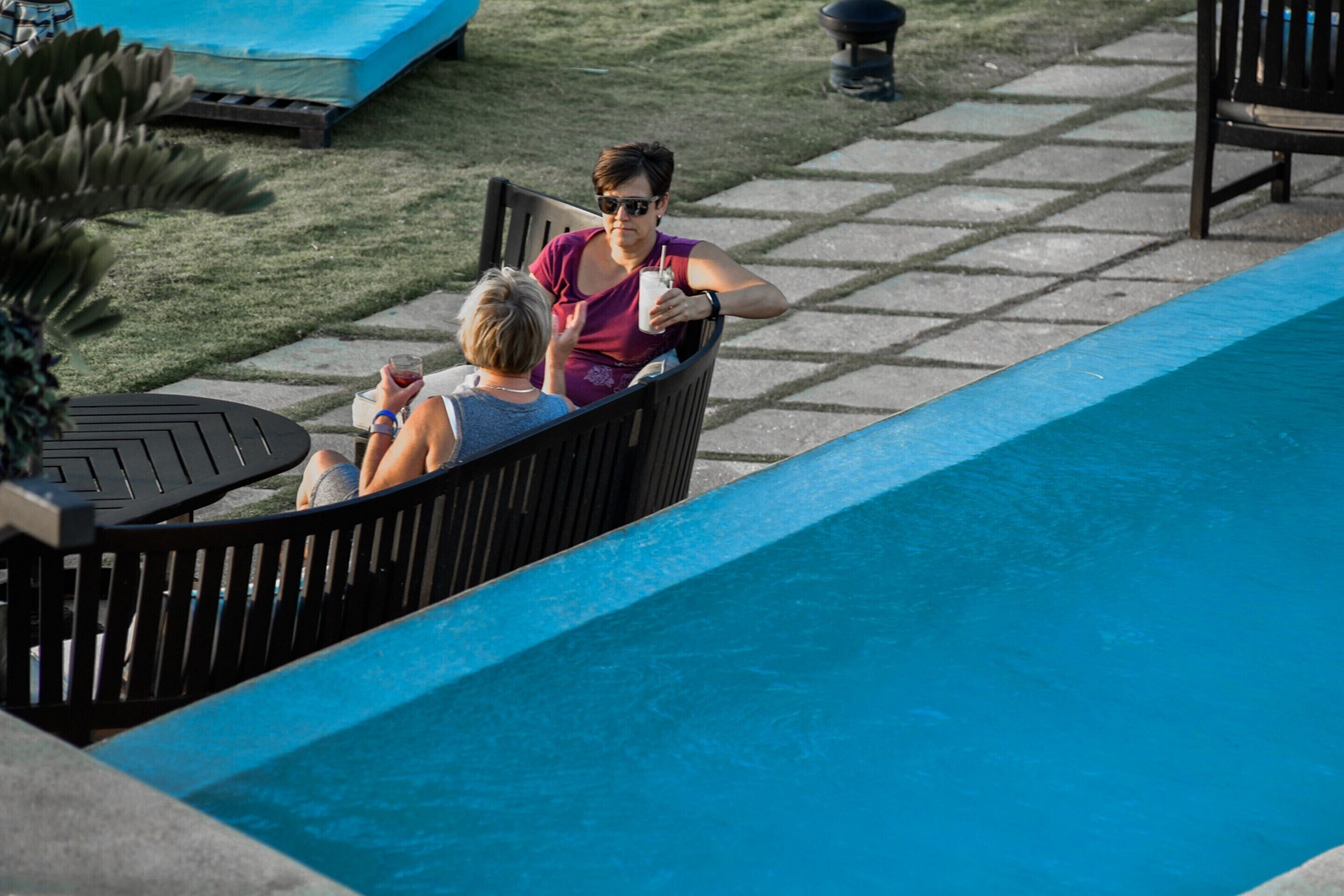 Zona junto a la piscina con mobiliario y una piscina.