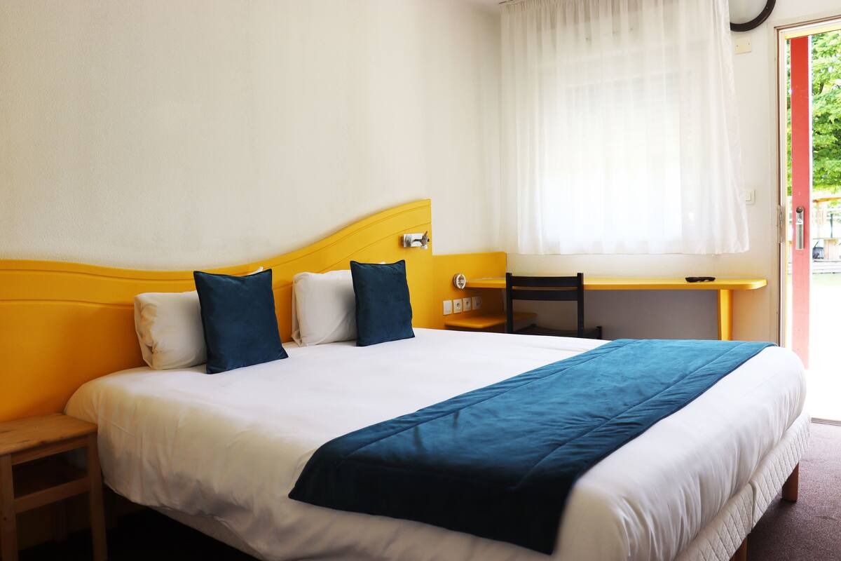 Ein Hotelzimmer mit einem Bett, einem Schreibtisch und einem Stuhl.