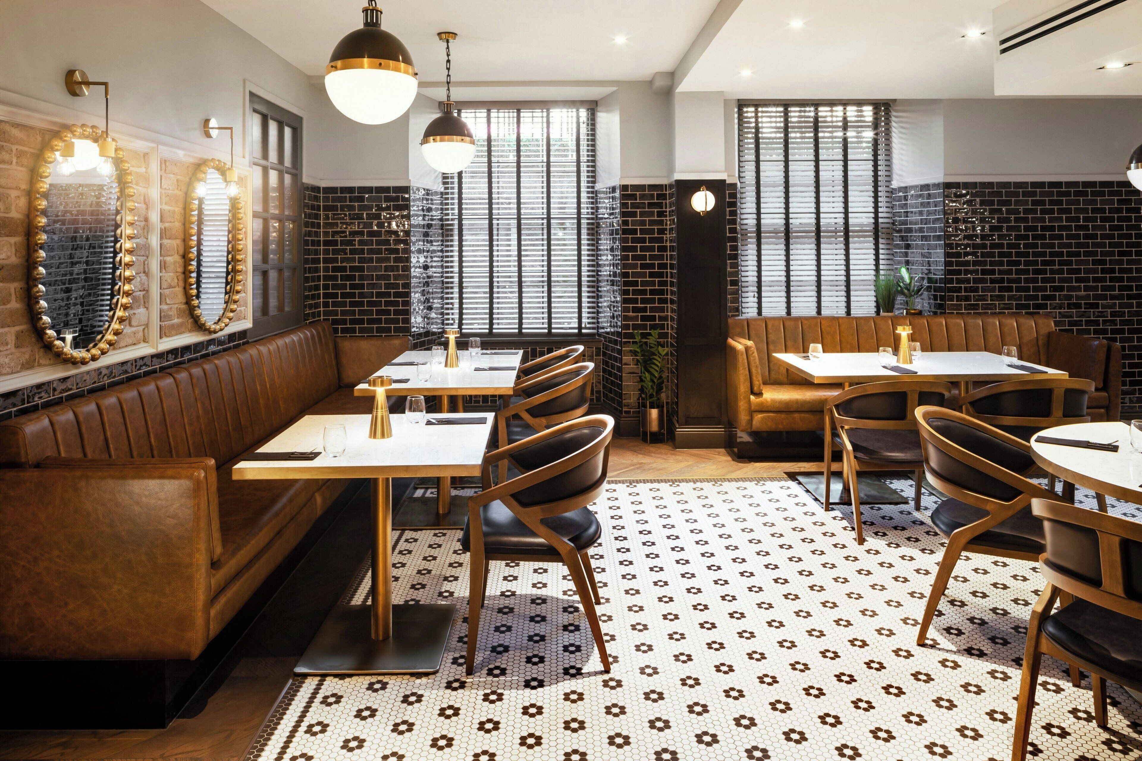 A restaurant interior with wooden booths, tables, and chairs.