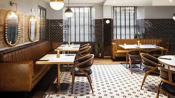 A restaurant interior with wooden booths, tables, and chairs.