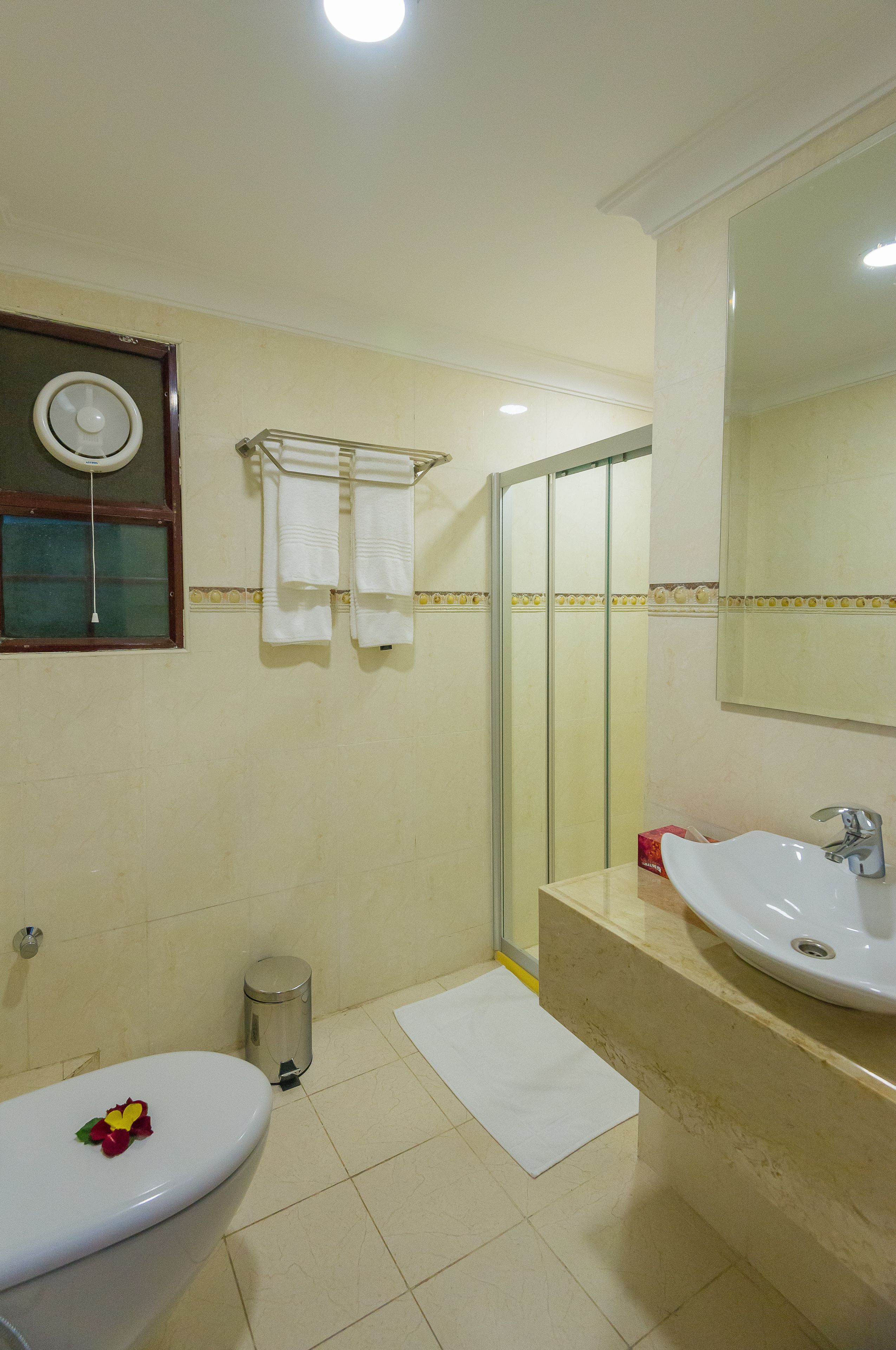 Een badkamer met toilet, wastafel en douche.