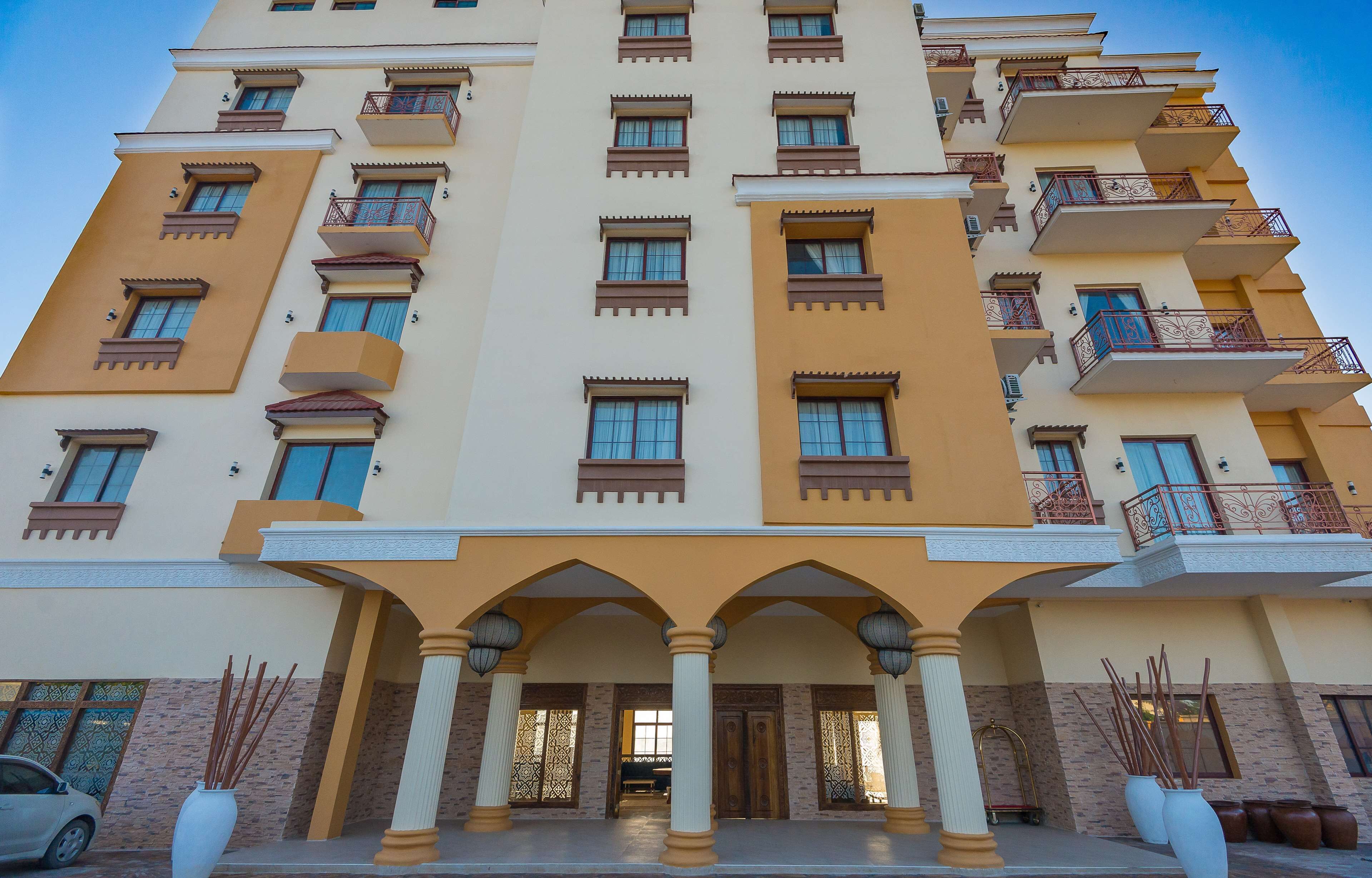 A multi-story hotel with balconies, large windows, and a central entrance with columns.