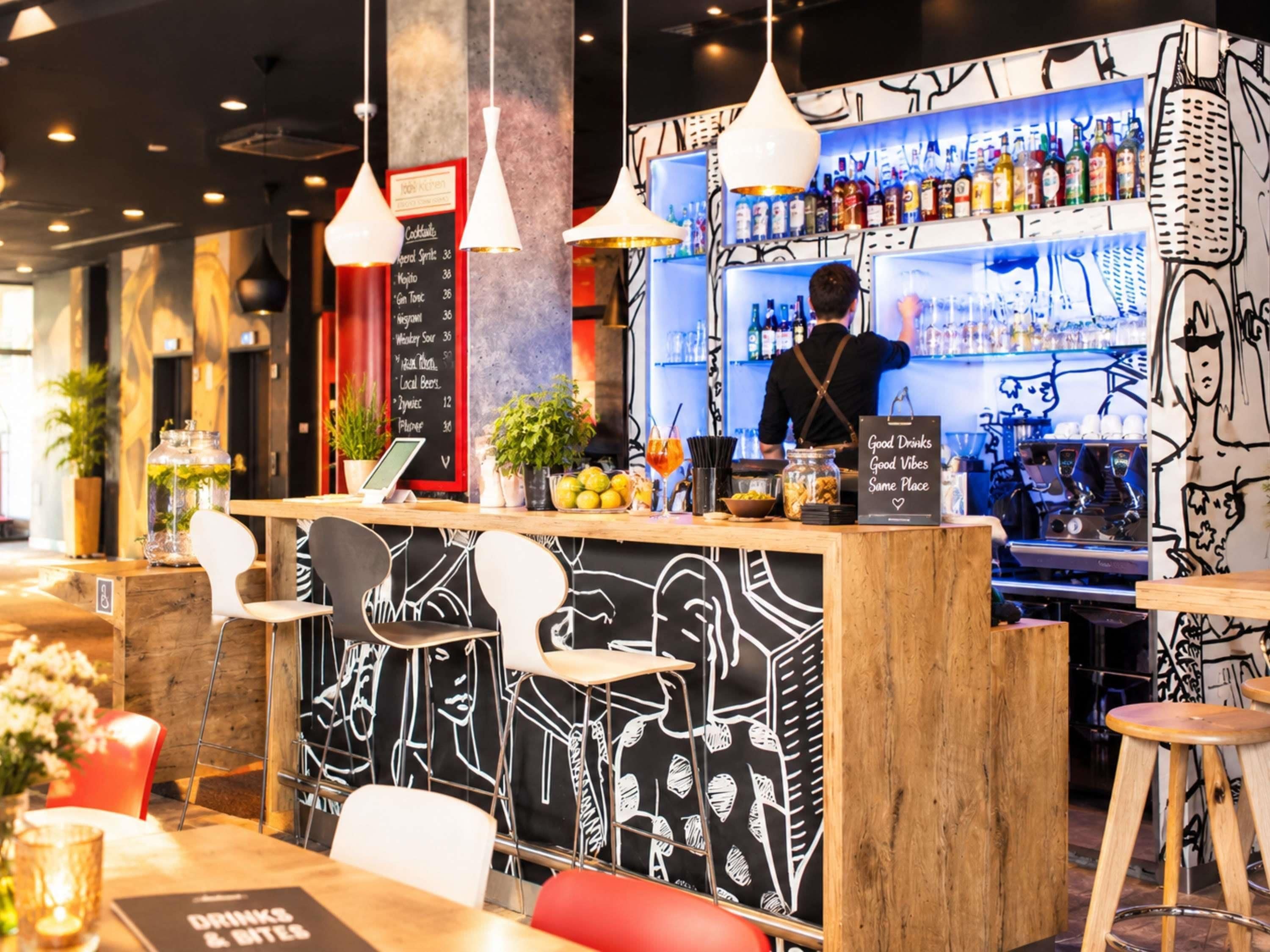 Un espace bar avec un comptoir, des tabourets de bar et un tableau affichant le menu.
