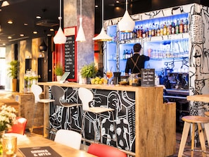 Een bar met een toonbank, barstoelen en een menukaart.