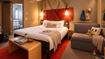 A hotel room with a bed, bedside table, chair, and a red carpet.