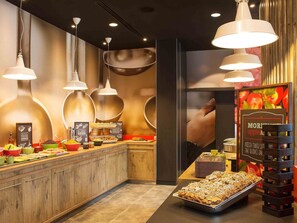 Zona de buffet per esmorzar amb diverses opcions gastronòmiques i una gran exhibició de fruita.