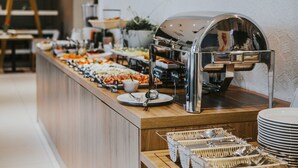 Montaje tipo bufé con diversos alimentos y una estación de bebidas de servicio libre.