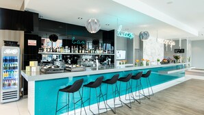 Zona de bar moderna con piscina, taburetes y un letrero de neón.