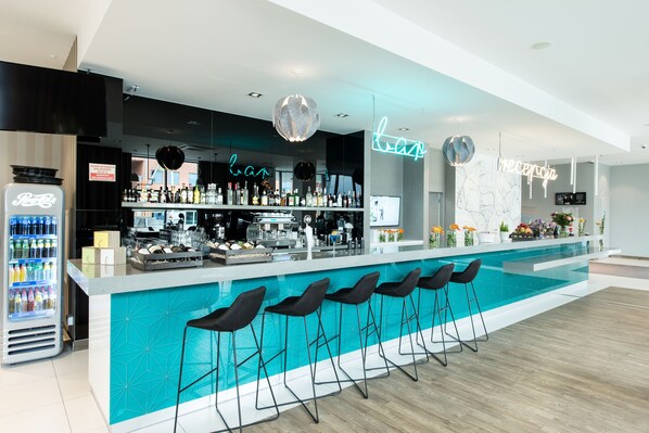 A modern bar area with a pool, bar stools, and a neon sign. - ibis Styles Siedlce (Siedlce)