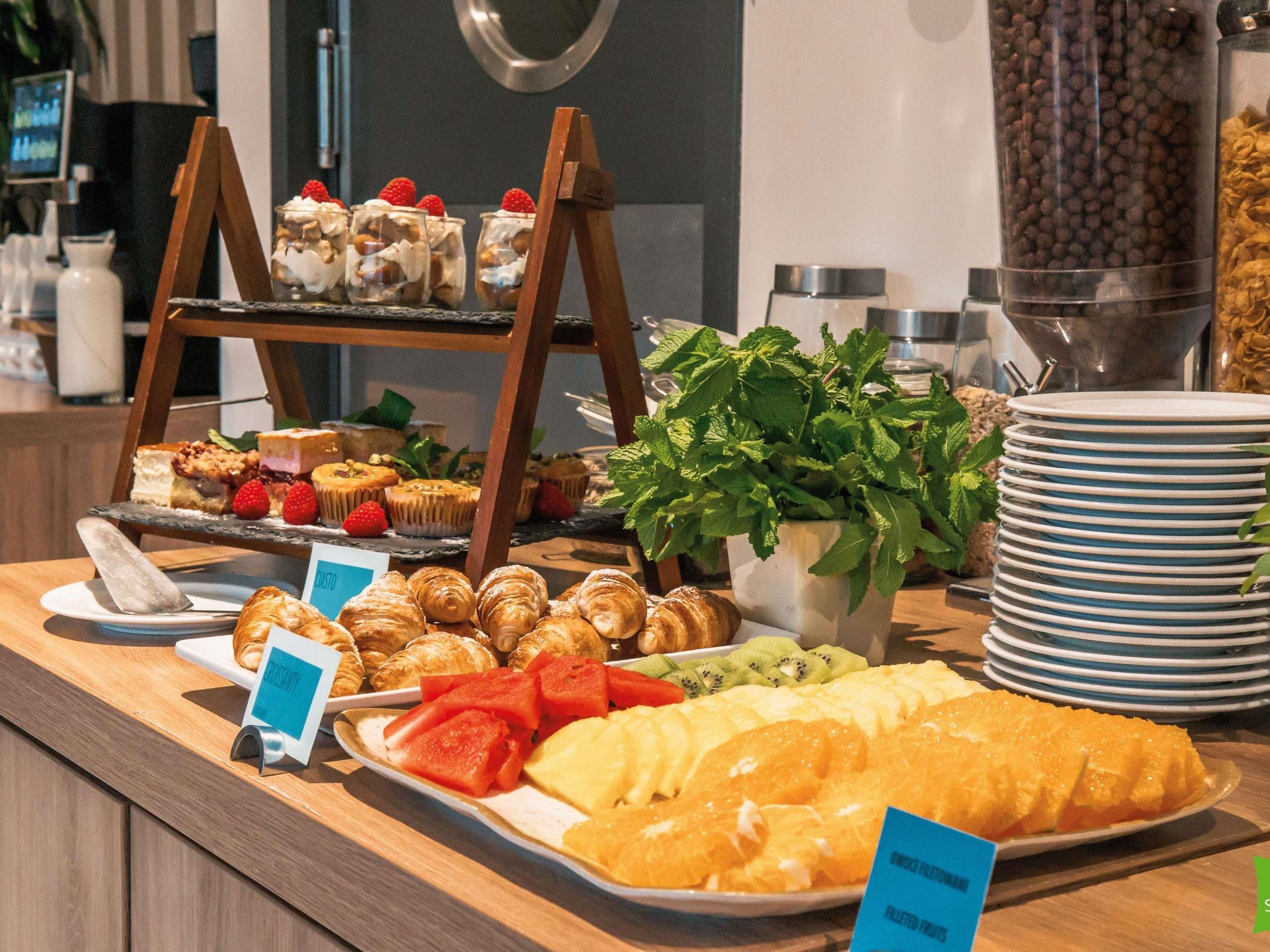 A buffet with various food items including pastries, fruits, and desserts.