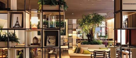 A modern interior with open shelving, seating areas, and indoor plants.