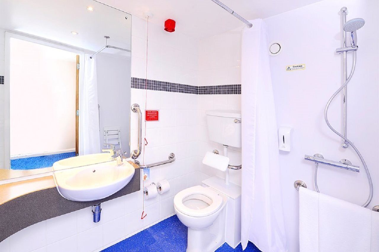 A modern bathroom with a white sink, toilet, and shower.