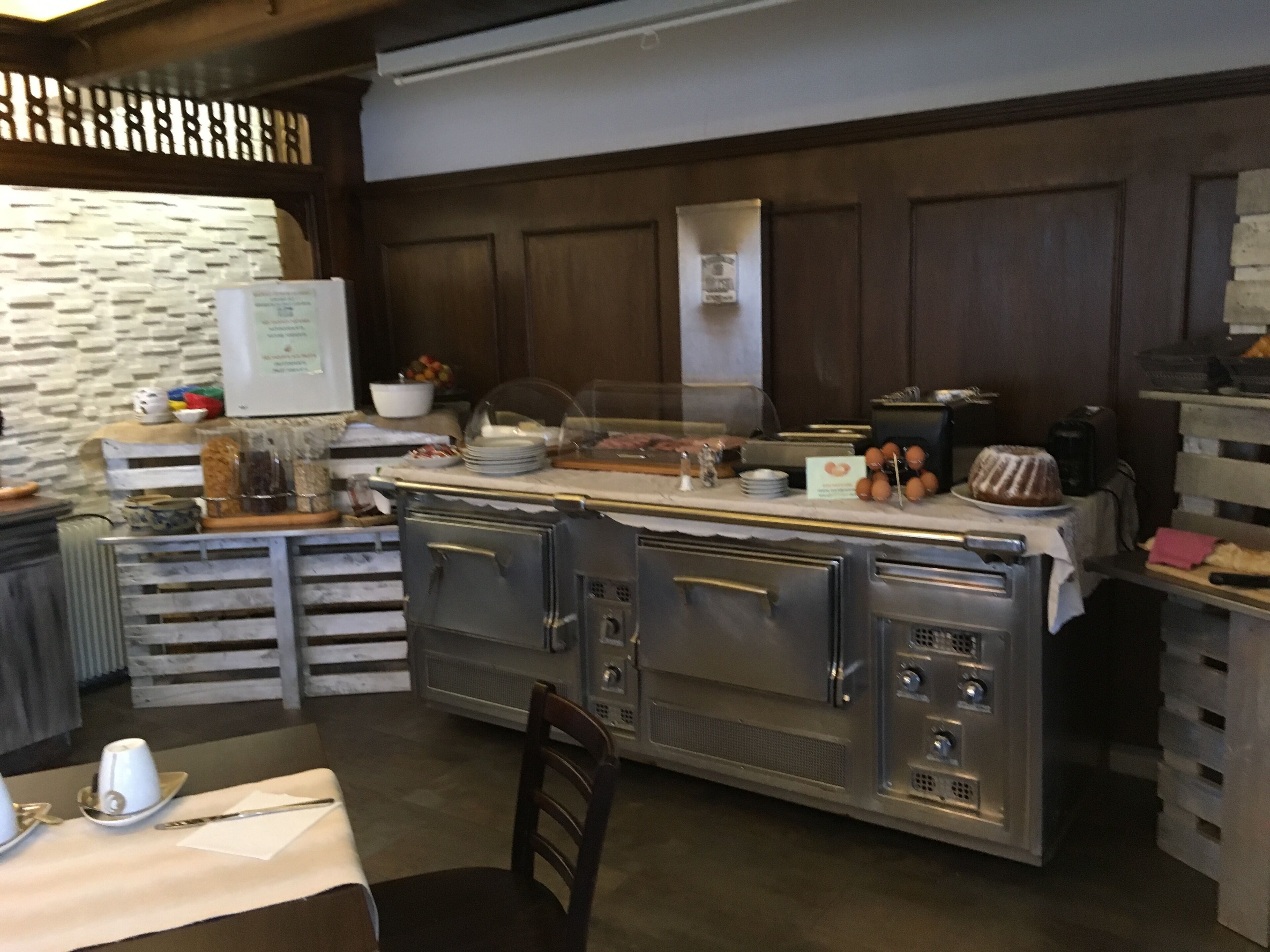 A kitchen with a marble countertop, wooden cabinets, and a whiteboard.