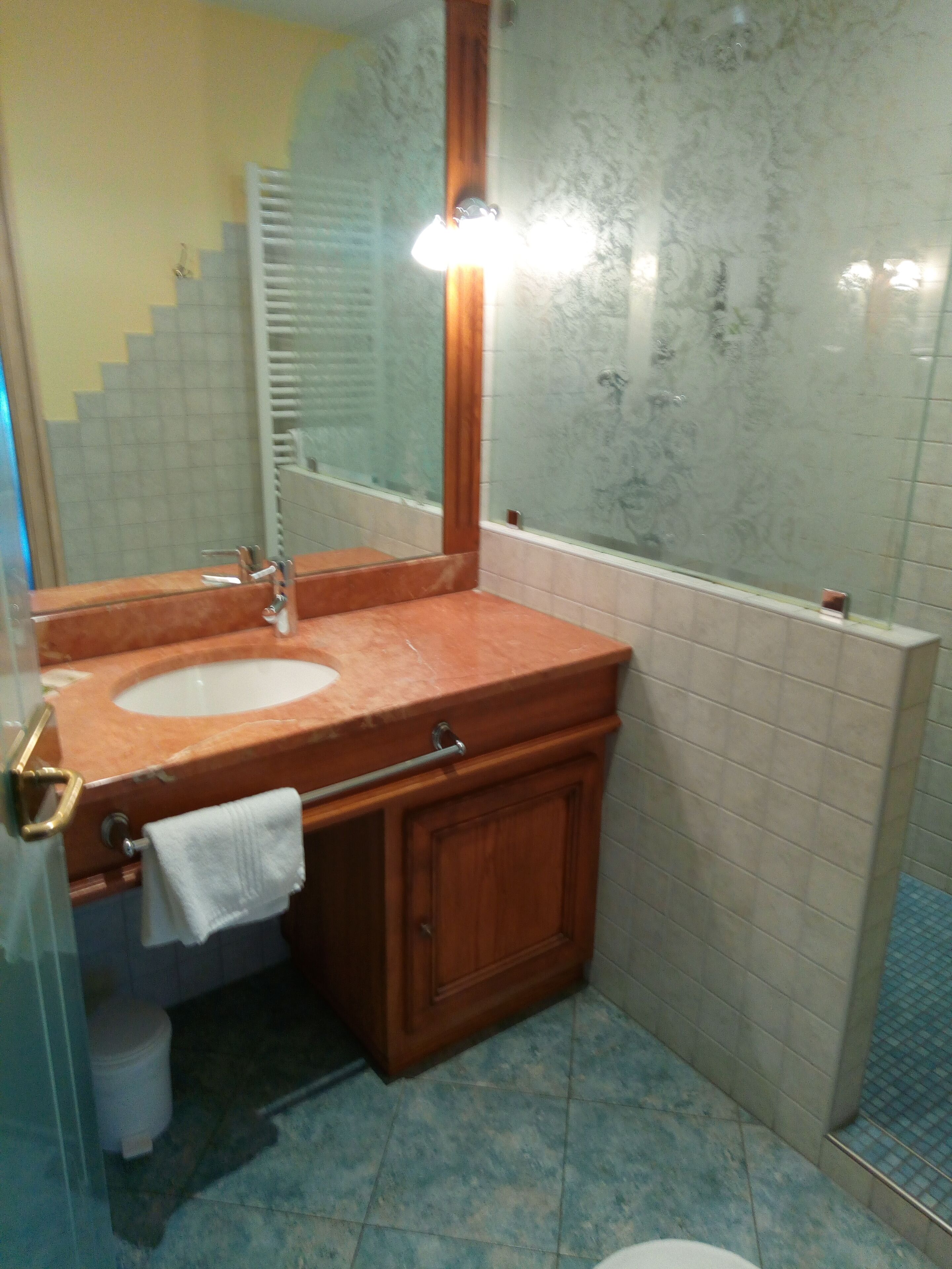 Un baño con lavamanos, espejo y ducha.