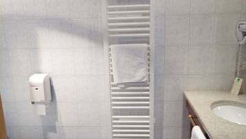 A bathroom with a toilet, sink, and towel rack.