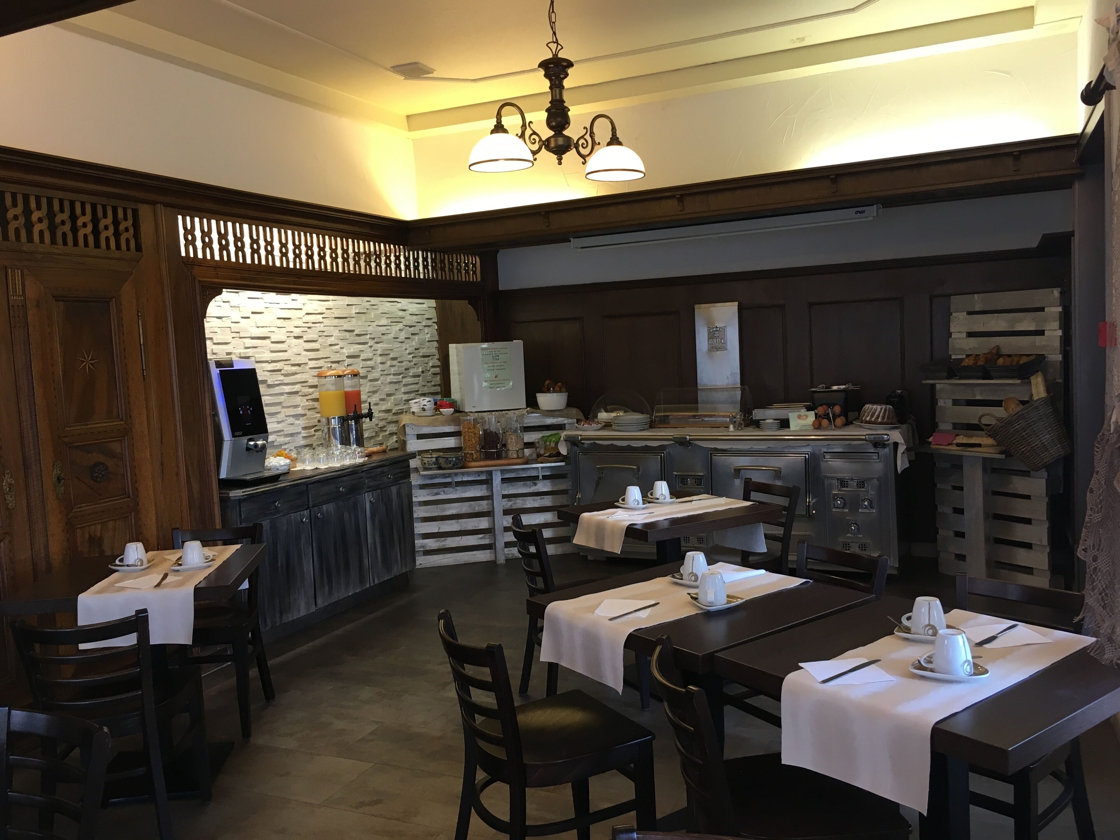 A restaurant with a bar area, wooden furniture, and a stone wall.
