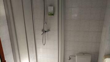 A bathroom with a shower, toilet, and sink.