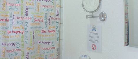 A bathroom with a toilet, sink, and shower curtain with motivational words.