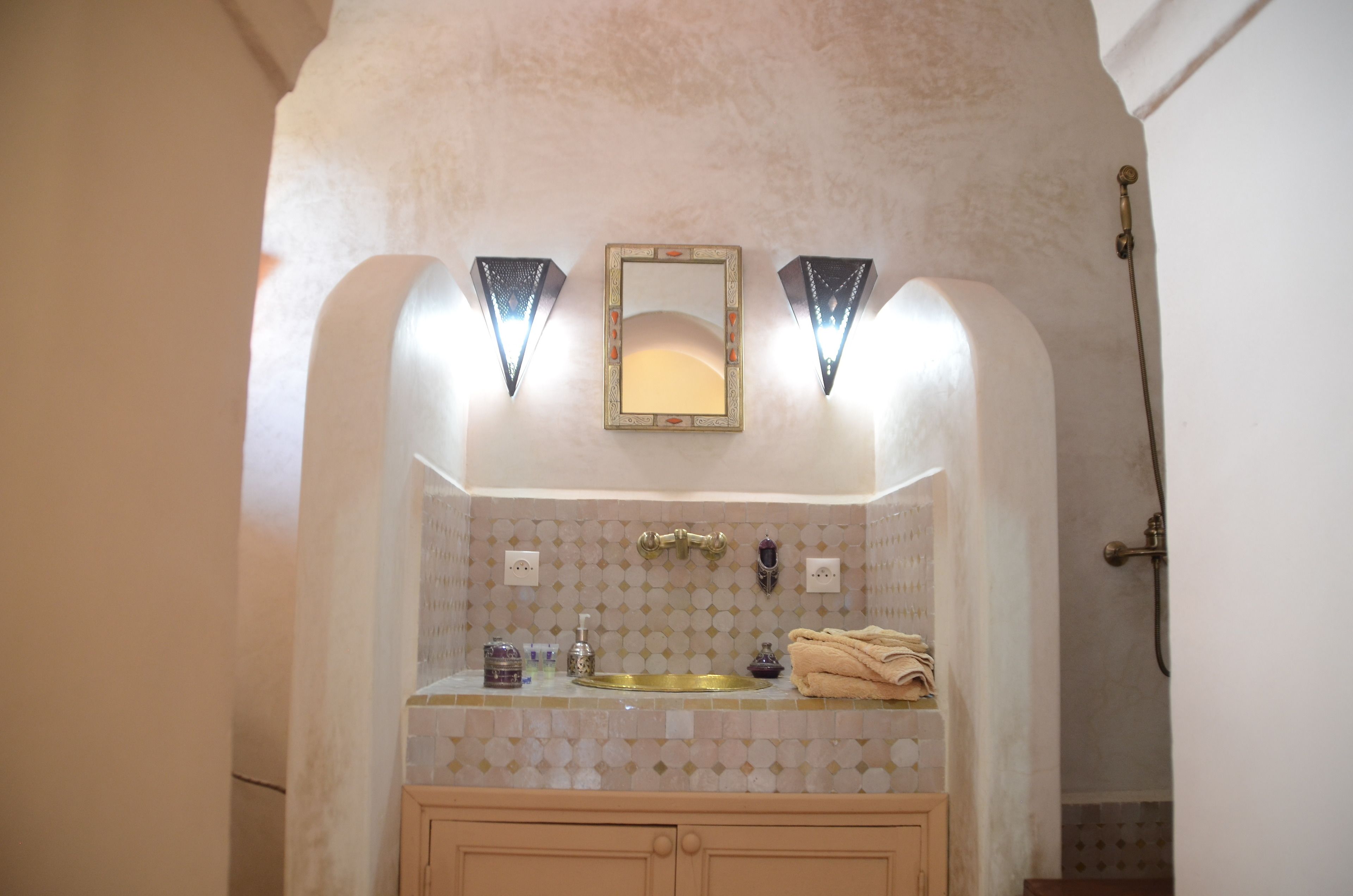 A bathroom with a sink, mirror, and towel rack.