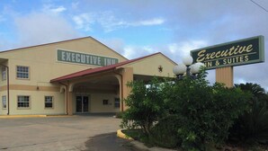 A hotel with a sign reading 'EXECUTIVE INN & SUITES' and a covered entrance. - Executive Inn & Suites Schulenburg (Schulenburg)