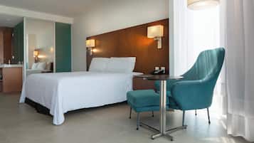 Une chambre d’hôtel avec un lit, un bureau, une chaise et un miroir.