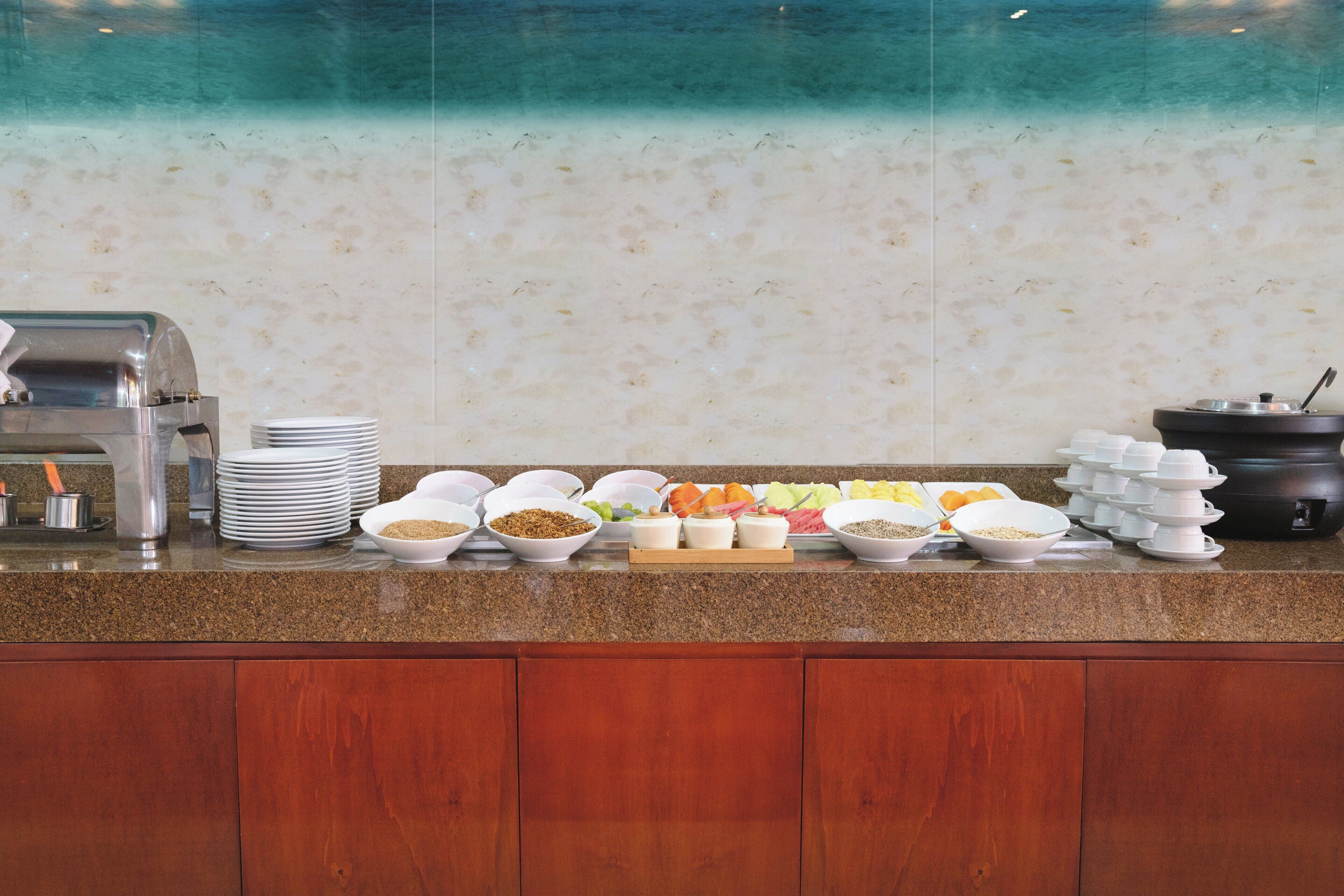 A buffet setup with various food items and a coffee machine.
