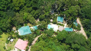 An aerial view of a resort with multiple buildings, a swimming pool, and lush greenery. - Hotel El Pequeño Gecko Verde (Sámara)