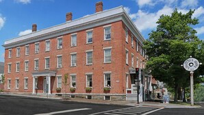 A historic red brick building with a white trim, multiple windows, and a sign indicating it is a hotel. - The Lincklaen House (Cazenovia)