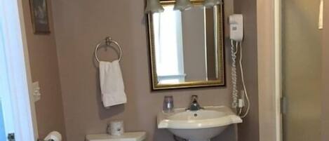 Une petite salle de bain avec des toilettes, un lavabo et un miroir.