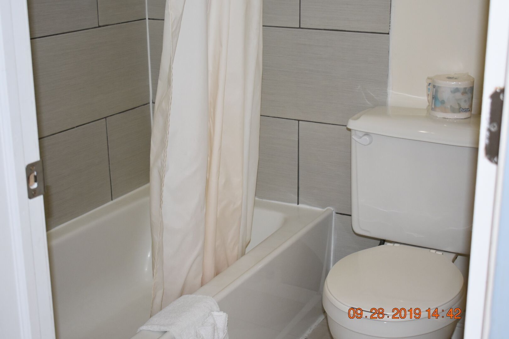 Un baño con bañera, inodoro y cortina de ducha.