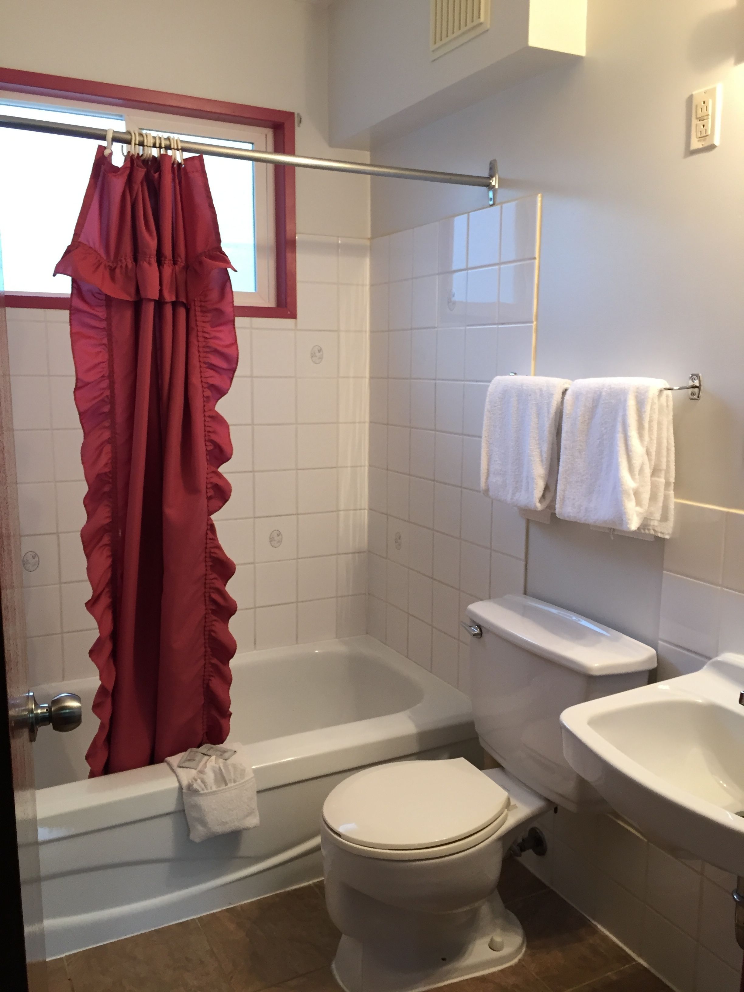 Et badeværelse med badekar, toilet og håndvask.