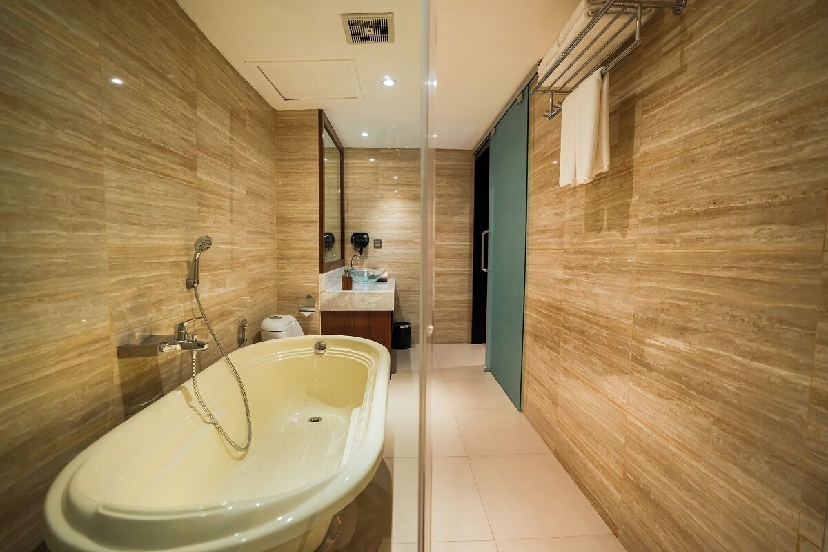 Ein modernes Badezimmer mit freistehender Badewanne, einem Waschtisch mit Spiegel und einem Handtuchhalter.