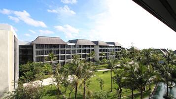 Un hotel con varias construcciones, una zona de piscina y abundante vegetación.