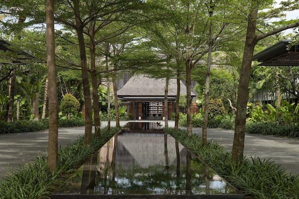 A serene courtyard with a central water feature, surrounded by lush greenery and a traditional building. - The Anvaya Beach Resort Bali (Kuta)
