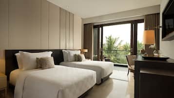Ein Hotelzimmer mit zwei Betten, einem Schreibtisch und einem großen Fenster mit Blick auf Palmen.