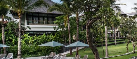 A resort with a pool area, lounge chairs, and umbrellas.