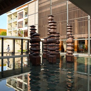 Un bâtiment moderne doté d’un atrium en verre, agrémenté de lanternes de style pagode traditionnel.