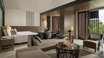 Ein modernes Hotelzimmer mit Bett, Sofa, Sesseln und einem Glastisch.
