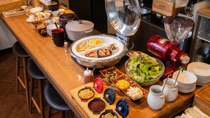 A buffet setup with various food items and a coffee machine. - APA Hotel Ochanomizu Ekikita (Tokyo)