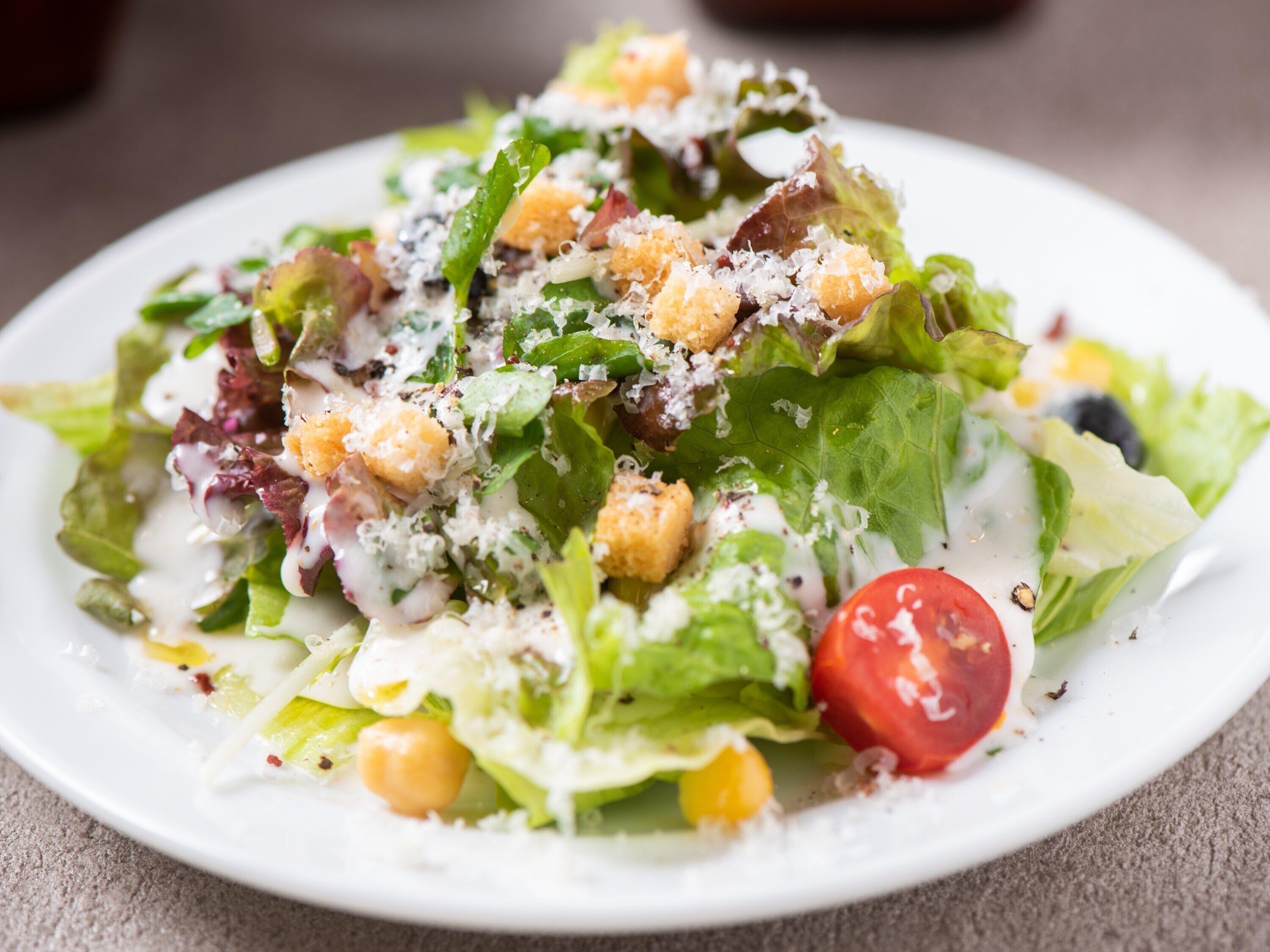 Une salade composée de divers ingrédients, présentée dans une assiette.
