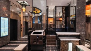 A modern hotel lobby with marble flooring, a reception desk, and a digital floor guide. - APA Hotel Ochanomizu Ekikita (Tokyo)
