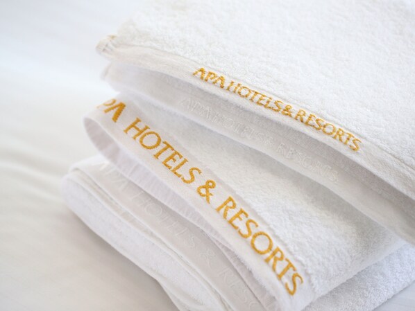 A stack of white towels with embroidered text reading "AAA HOTELS & RESORTS". - APA Hotel Ochanomizu Ekikita (Tokyo)