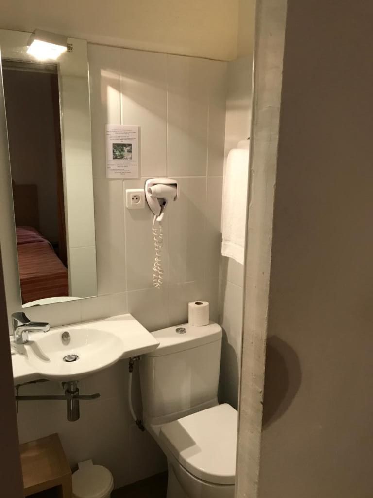 Une petite salle de bain avec un lavabo, des toilettes et un miroir.