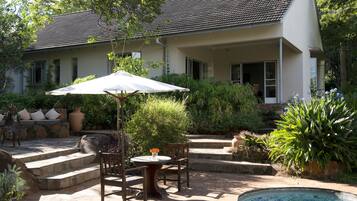 A house with a patio area featuring a pool, outdoor furniture, and a covered seating area.